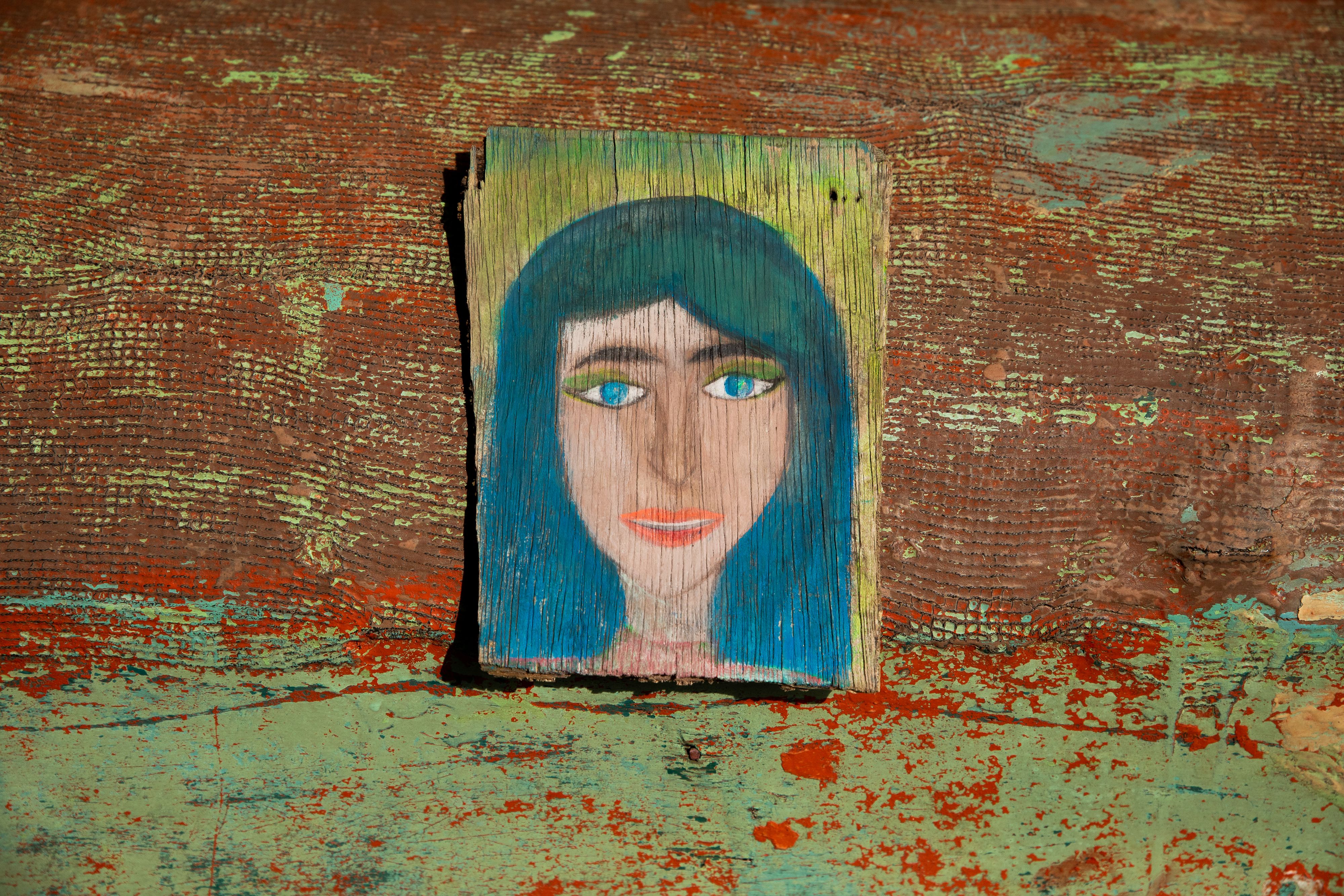A close up photo of one of Arnold's objects of memory: paintings on broken pieces of wood