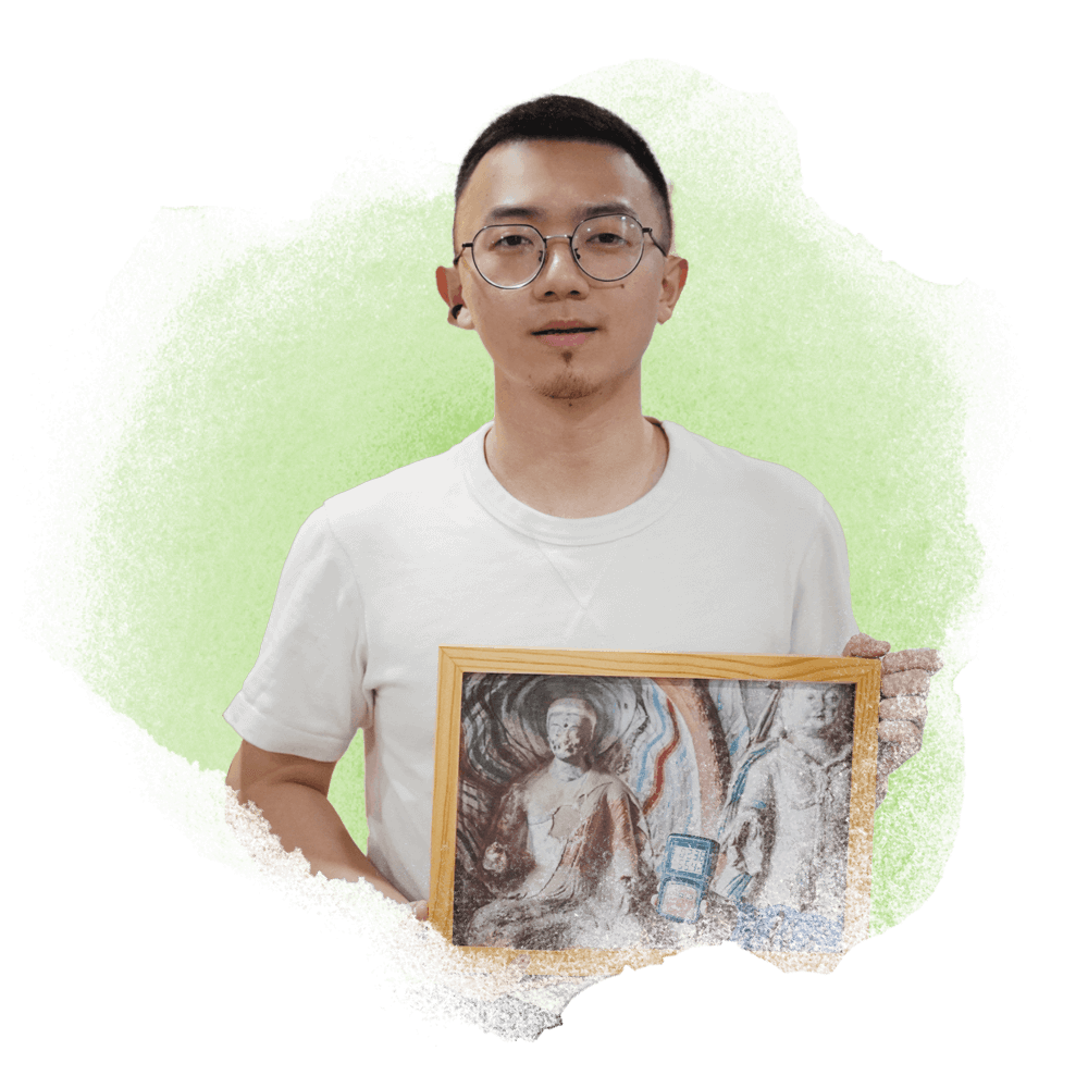 A portrait of Yan Tu holding his object of memory: a photo of a decaying Buddha statue in a temple