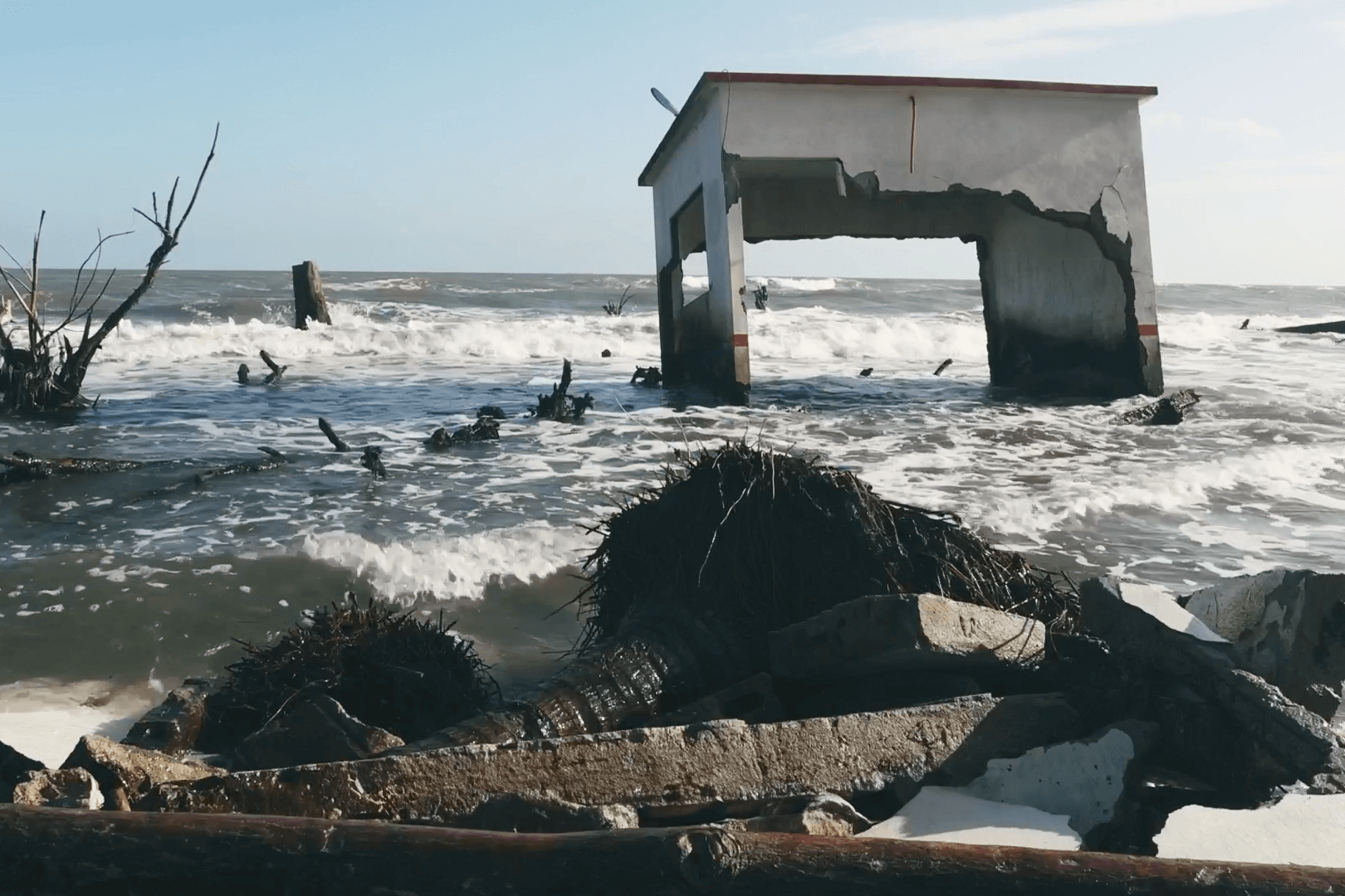 A portrait of a destroyed house partially submerged in the sea